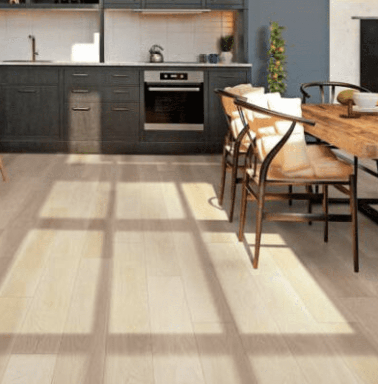 A kitchen with wooden floors and chairs.