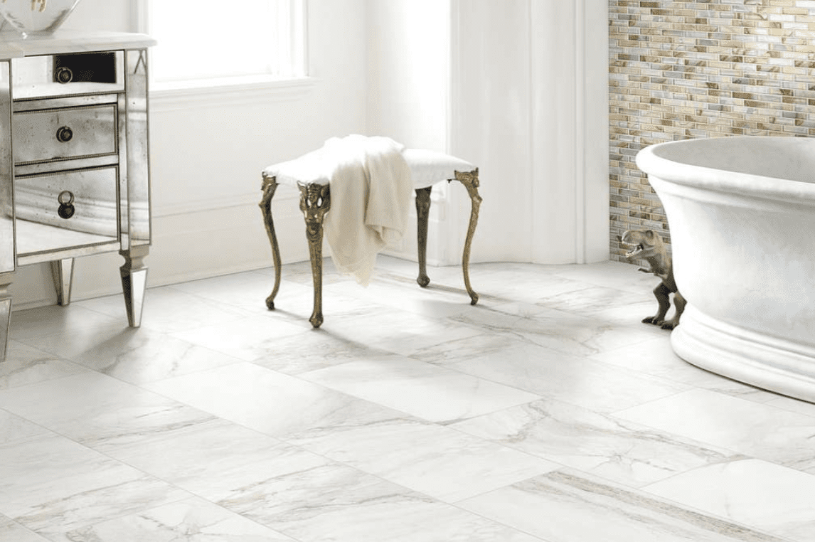 A bathroom with white tile floors and a gold bench.