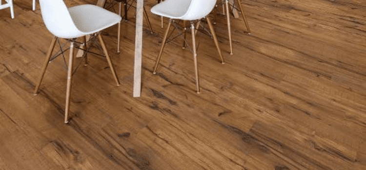 A wooden floor with chairs and tables in the background.