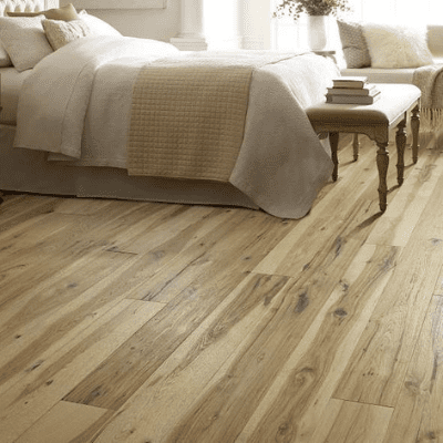 A bedroom with wood floors and a bed