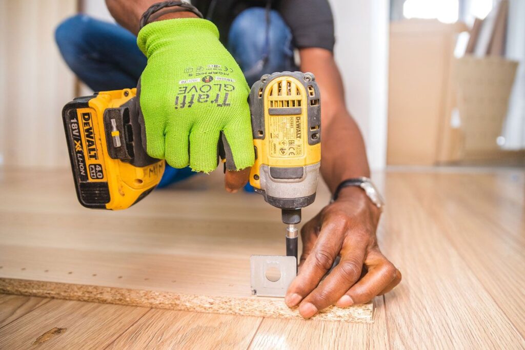 A person using a drill to install the floor.