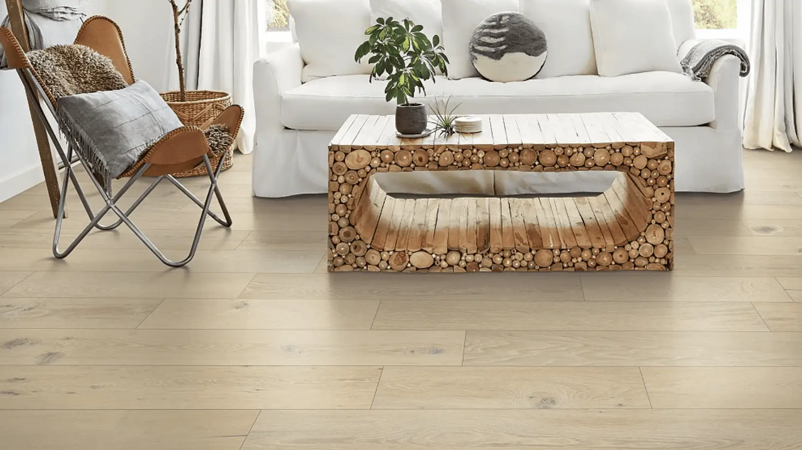 A living room with white furniture and wood floors.