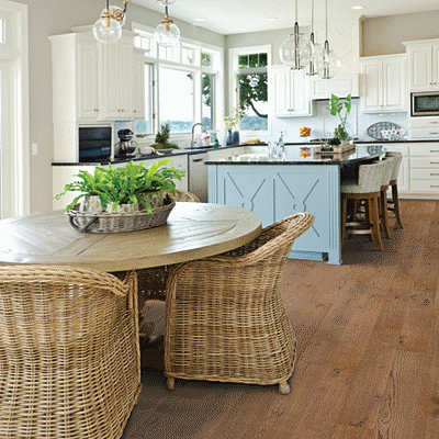 A kitchen with wooden floors and white cabinets.