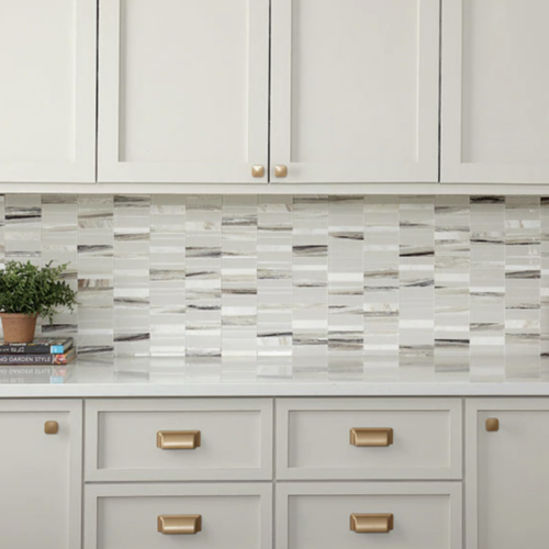 A kitchen with white cabinets and tiled backsplash.