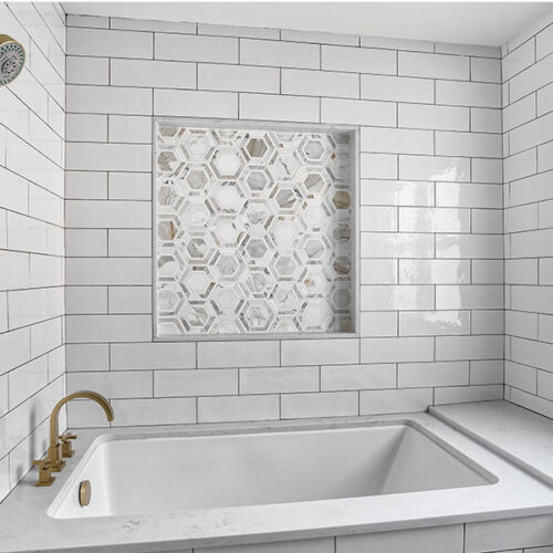 A bathroom with white tile and marble tiles.